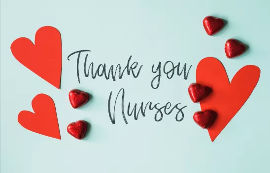 Auf einem hellblauen Hintergrund steht die schwarze Aufschrift "Thank you nurses". Drum herum liegen rote Herzen aus Pappe und Schokolade. Auf einem hellblauen Hintergrund steht die schwarze Aufschrift "Thank you nurses". Drum herum liegen rote Herzen aus Pappe und Schokolade.