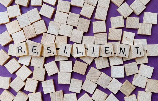 Holzplättchen, auf denen in einzelnen Buchstaben das Wort "RESILIENT" steht