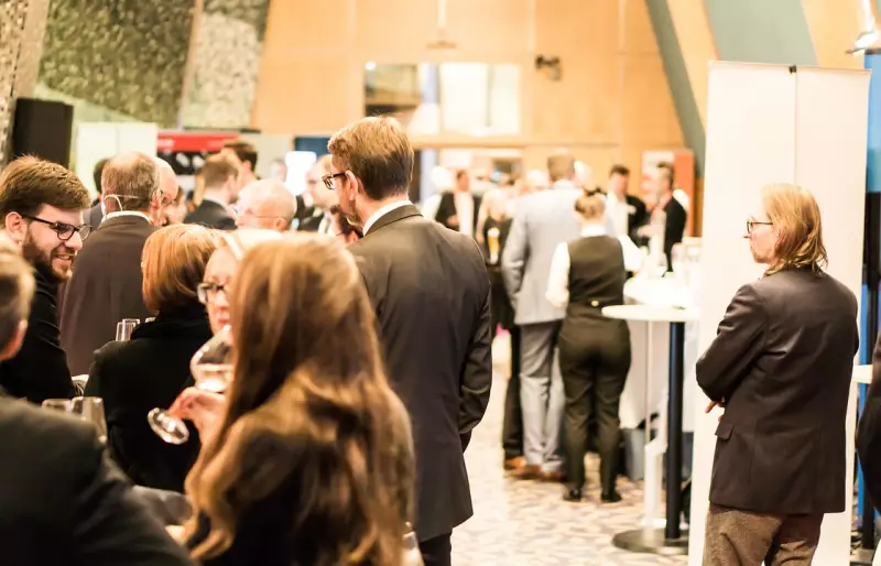 Teilnehmende unterhalten sich bei einem Empfang auf einer Konferenz