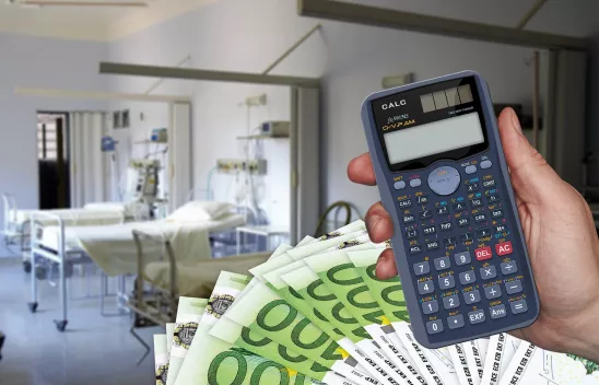 Ein Krankenhauszimmer mit mehreren leeren Betten. Unten rechts davor sind mehrere 100-Euro-Scheine und eine Hand, die einen Taschenrechner hält, eingeblendet. 