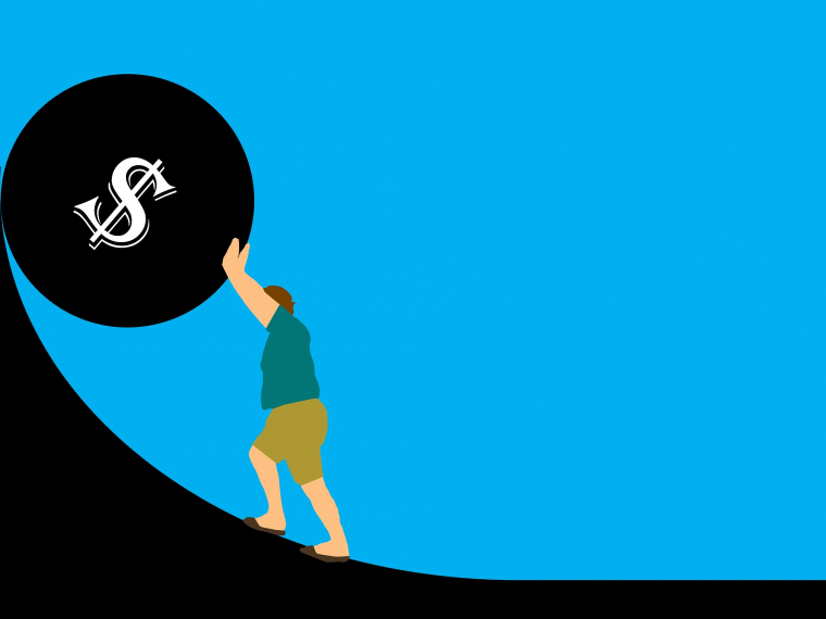 Eine Grafik von einem Mann, der vor blauem Hintergrund eine schwarze große Kugel, auf der ein $-Zeichen abgebildet ist, eine schwarze Steigung hinaufschiebt.