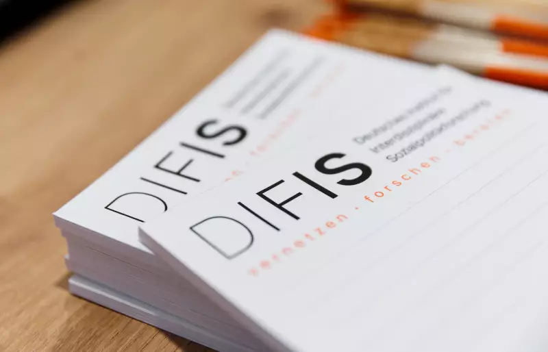 Mehrere linierte Notizblöcke mit DIFIS-Logo liegen auf einer Holzoberfläche