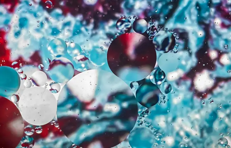 Eine Nahaufnahme von blauem Wasser und Blasen auf einer Oberfläche symbolisiert Gruppen und Netzwerke, die der Artikel aufdeckt.