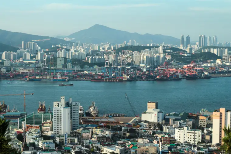 View of Busan city with skyscrapers and busy harbor.