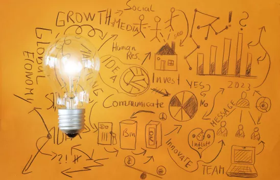 Kritzeleien auf orangenem Grund. Links liegt frotal eine große Glühbirne auf der Zeichnung. Kritzeleien auf orangenem Grund. Links liegt frotal eine große Glühbirne auf der Zeichnung.