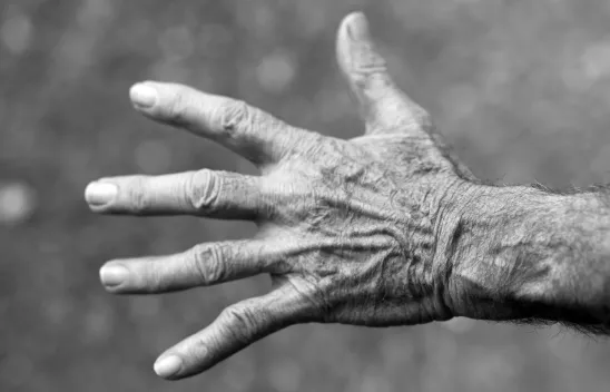 Nahaufnahme einer alten, faltigen Hand mit ausgestreckten Fingern in Schwarzweiß. Nahaufnahme einer alten, faltigen Hand mit ausgestreckten Fingern in Schwarzweiß.