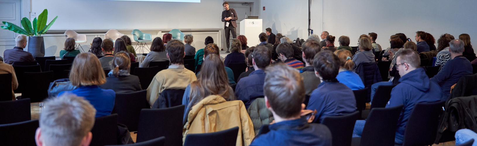 Person steht auf einer Bühne und präsentiert