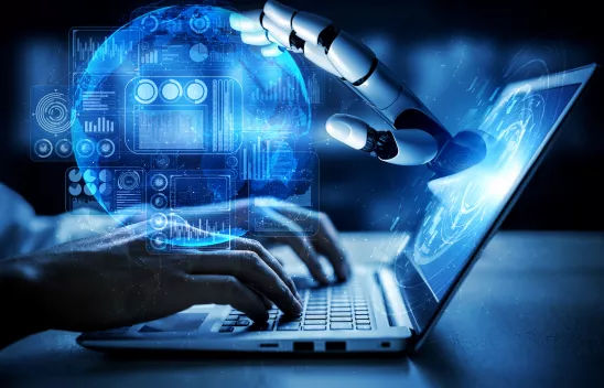 Aus einem Laptopbildschirm kommt eine Roboterhand, die eine digitale blaue Kugel berührt. Auf die Tastatur des Laptops tippen zwei Hände. Aus einem Laptopbildschirm kommt eine Roboterhand, die eine digitale blaue Kugel berührt. Auf die Tastatur des Laptops tippen zwei Hände.