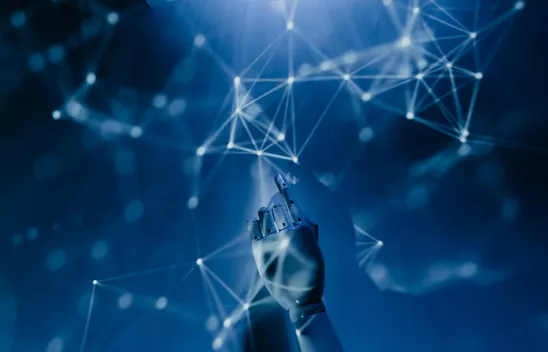  Ein futuristisches Bild mit einer Roboterhand, die auf ein Netzwerk aus leuchtenden, miteinander verbundenen Punkten zeigt, vor einem blauen Hintergrund.