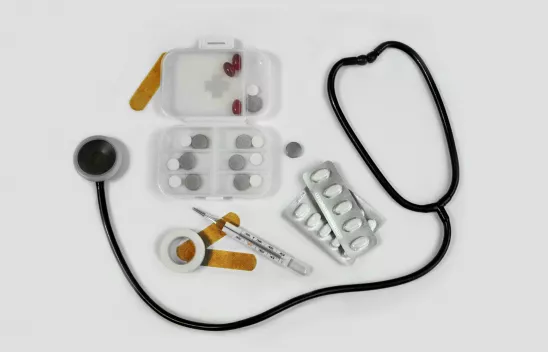Fotografie von Pillendosen, Pflaster, Fieberthermometer und Stethoskop vor einem weißen Hintergrund. Fotografie von Pillendosen, Pflaster, Fieberthermometer und Stethoskop vor einem weißen Hintergrund.