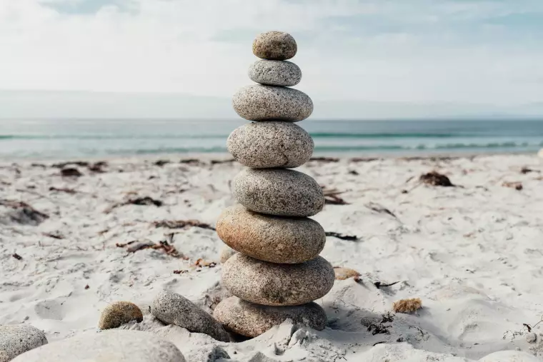 Ein Stapel balancierender Steine an einem Strand.