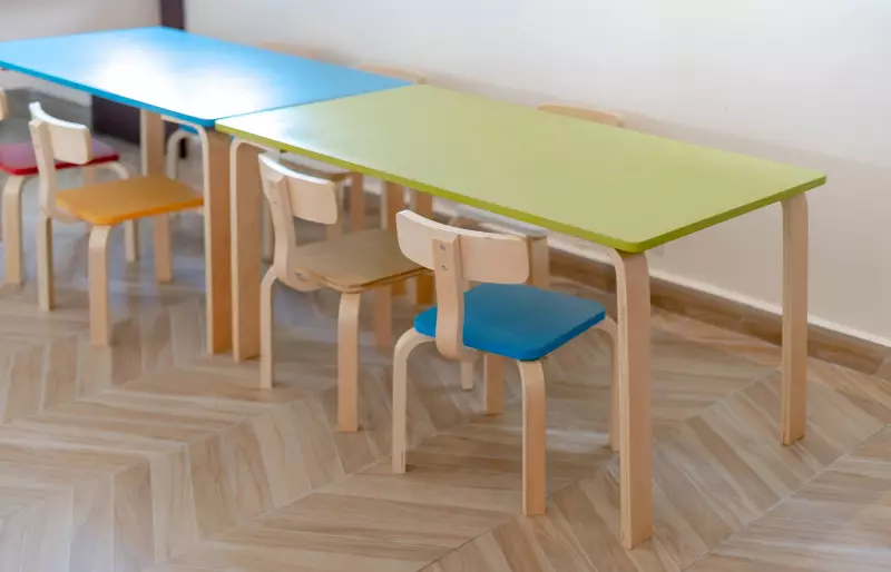 Mehrere bunte Kinderstühle stehen vor kleinen Kindertischen