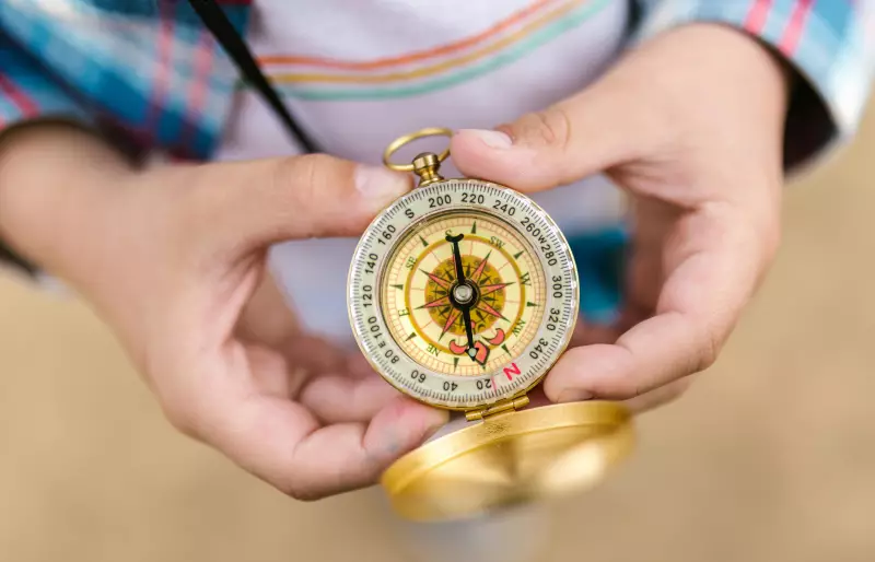 Eine Person hält einen Kompass in den Händen.