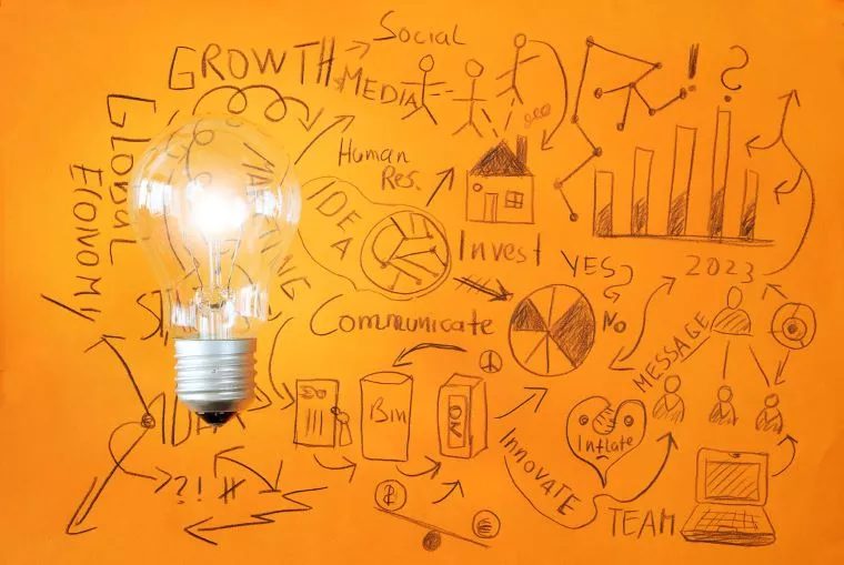 Kritzeleien auf orangenem Grund. Links liegt frotal eine große Glühbirne auf der Zeichnung.